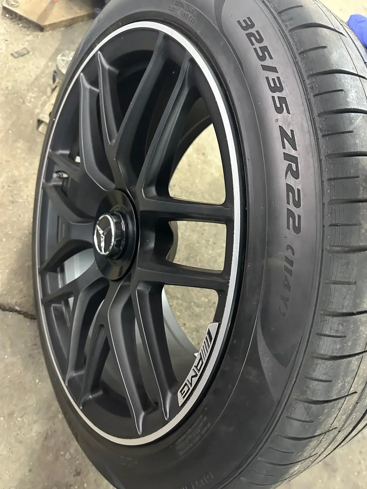 Zbliżenie koła z oponą 325/35 ZR22 i czarną felgą AMG