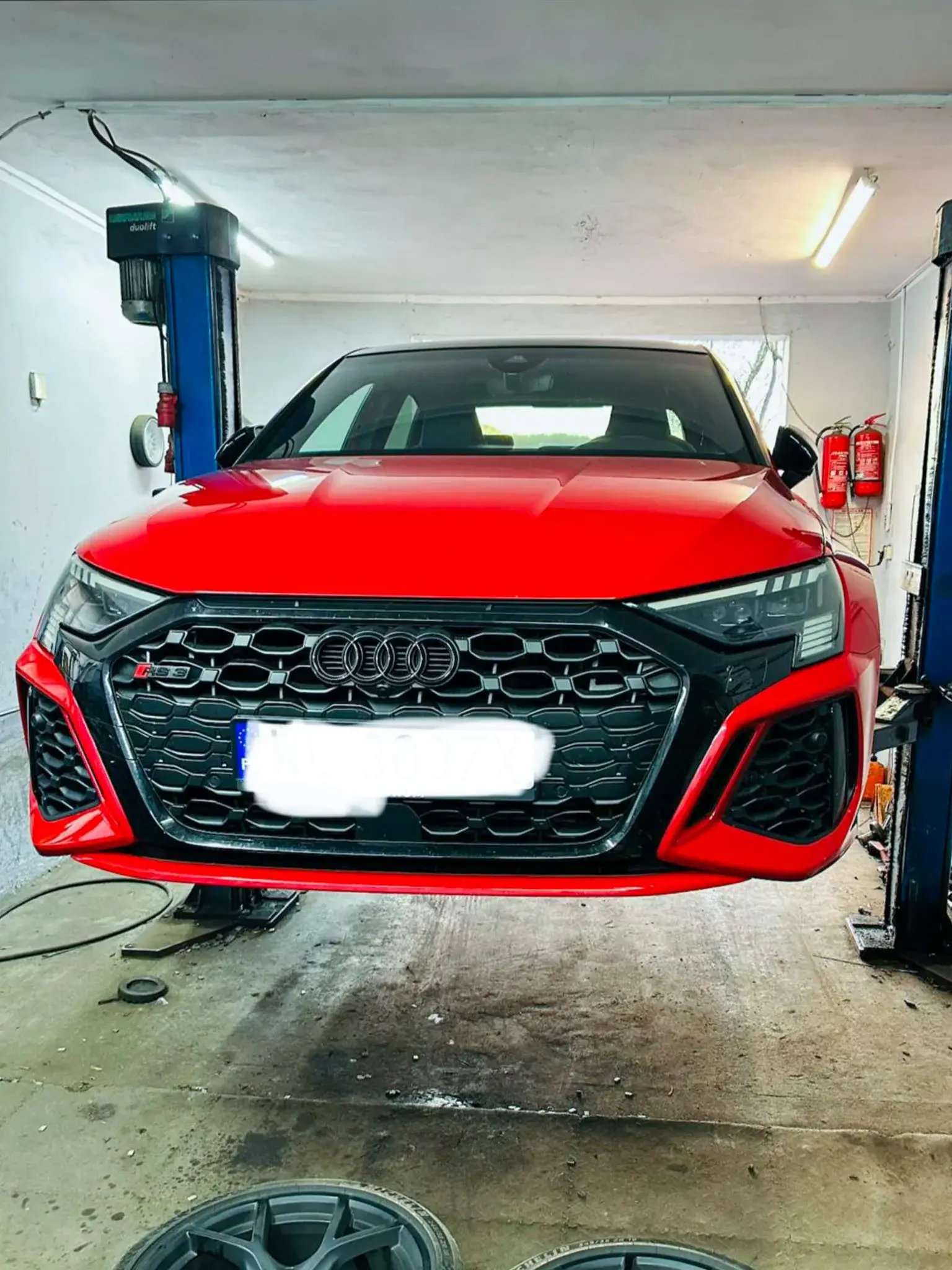 Czerwone Audi RS na podnośniku podczas serwisu kół