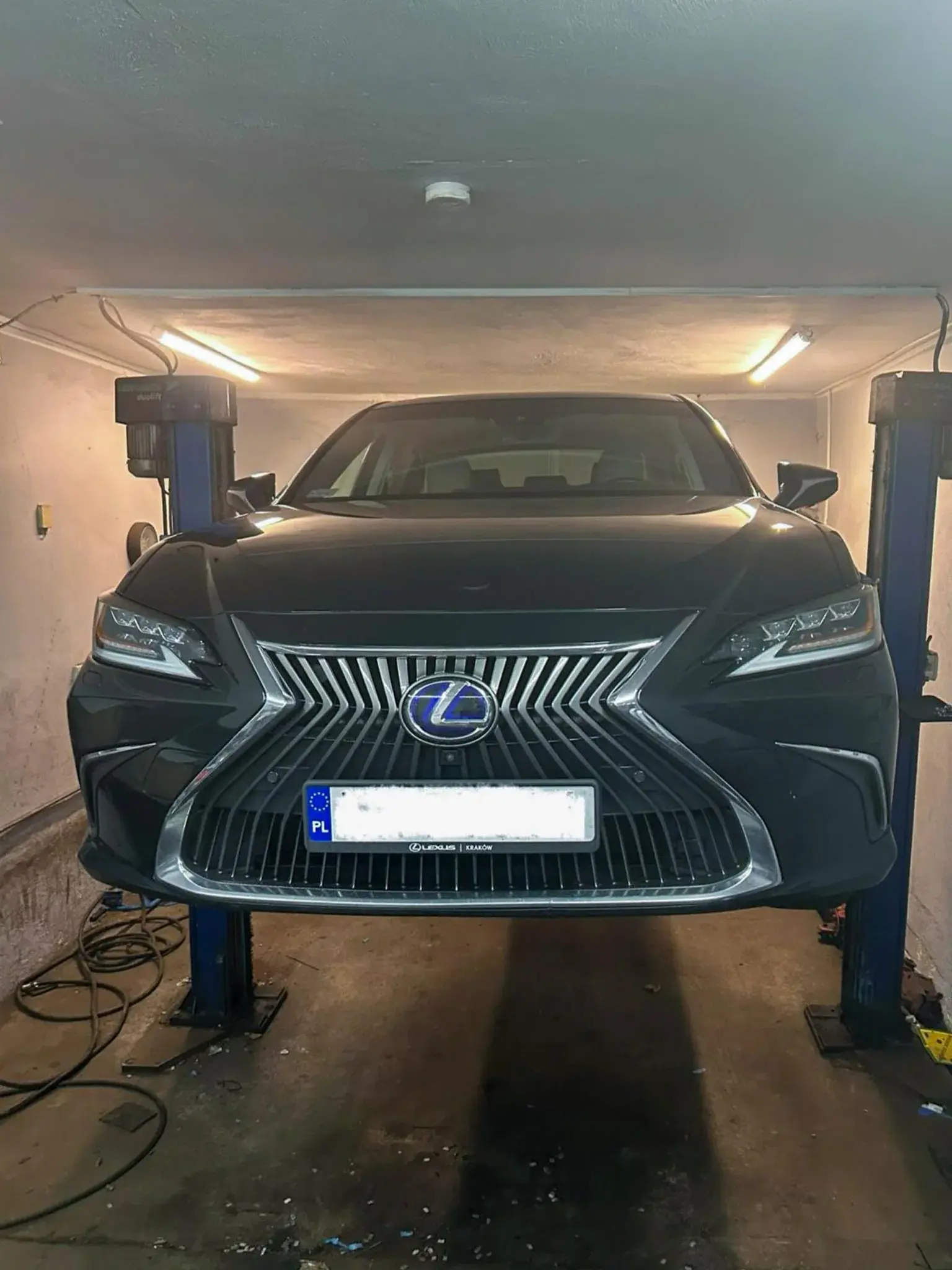 Czarny Lexus na podnośniku przygotowany do obsługi ogumienia