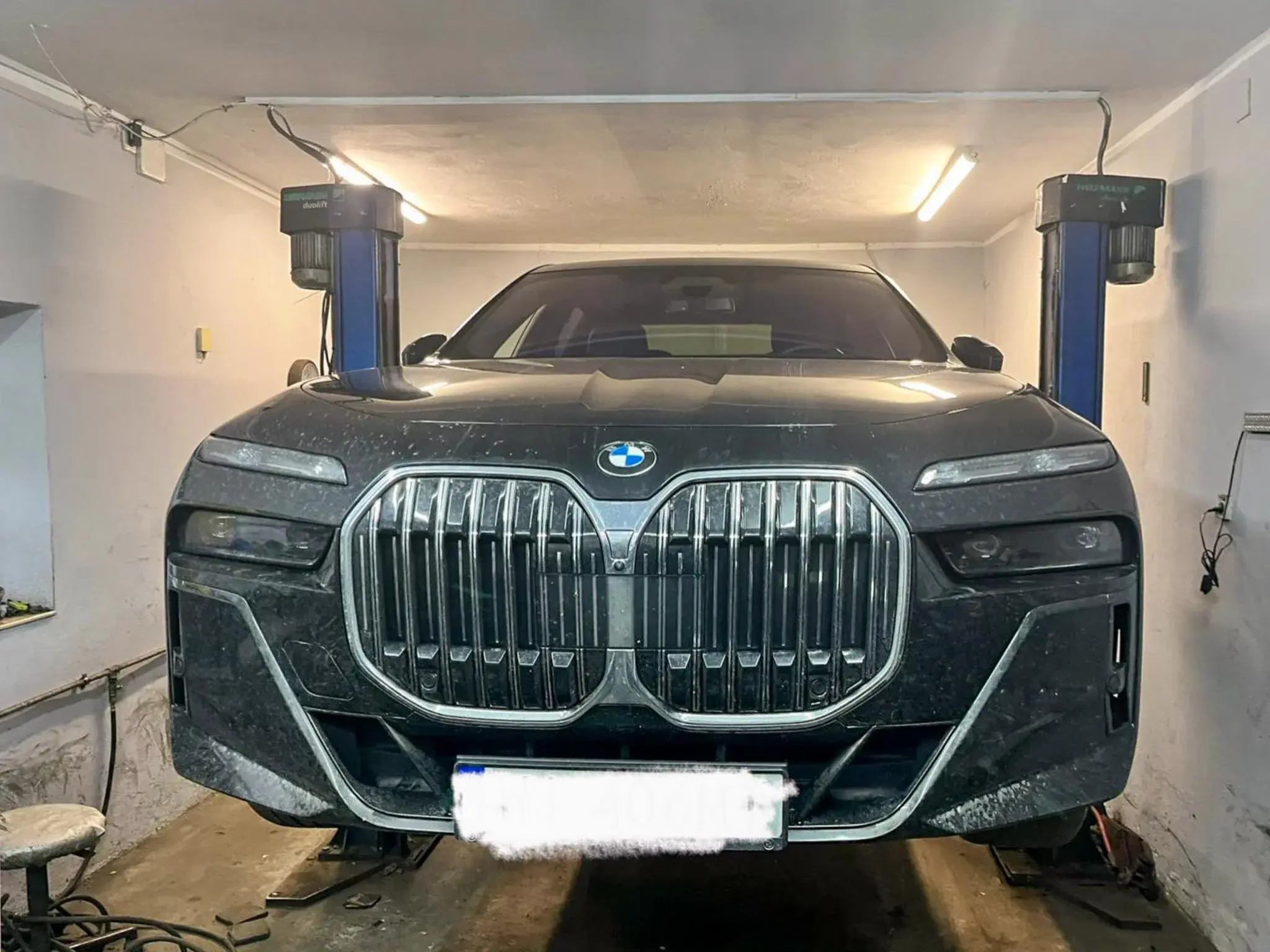 Czarne BMW z dużym grillem na stanowisku warsztatowym