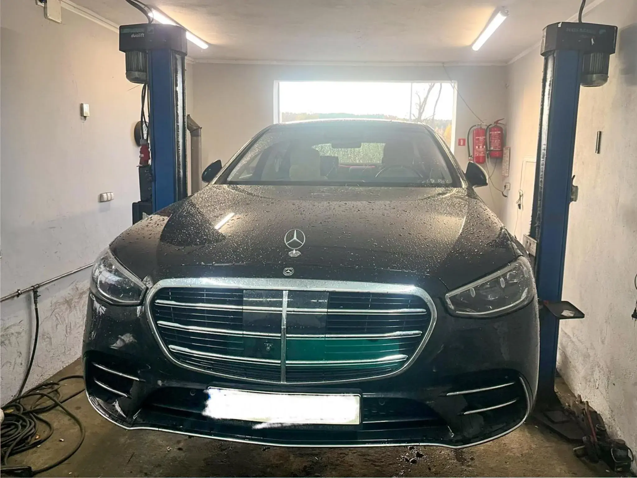 Czarna limuzyna Mercedes na podnośniku po serwisie