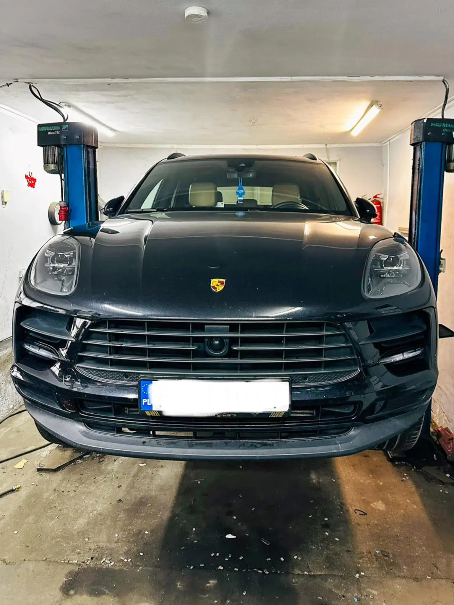 Czarny Porsche SUV na podnośniku podczas obsługi kół